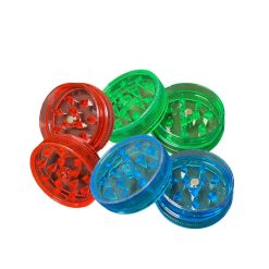 Grinders en plastique transparent de petite taille, disponibles en rouge, vert et bleu, avec des dents en forme de losange à l’intérieur.