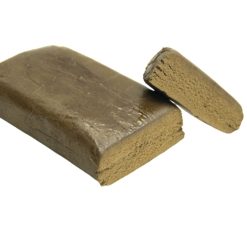 Bloc de résine marron clair avec une texture dense et une surface légèrement brillante, un morceau coupé en évidence.