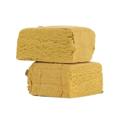 Deux morceaux de résine compressée jaune clair à la texture mousseuse, empilés l’un sur l’autre.