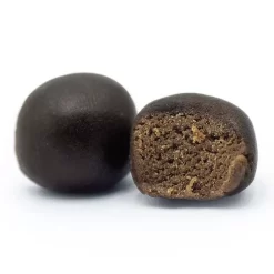 Deux boules de résine noire, l'une entière, l'autre coupée révélant une texture intérieure brun clair.